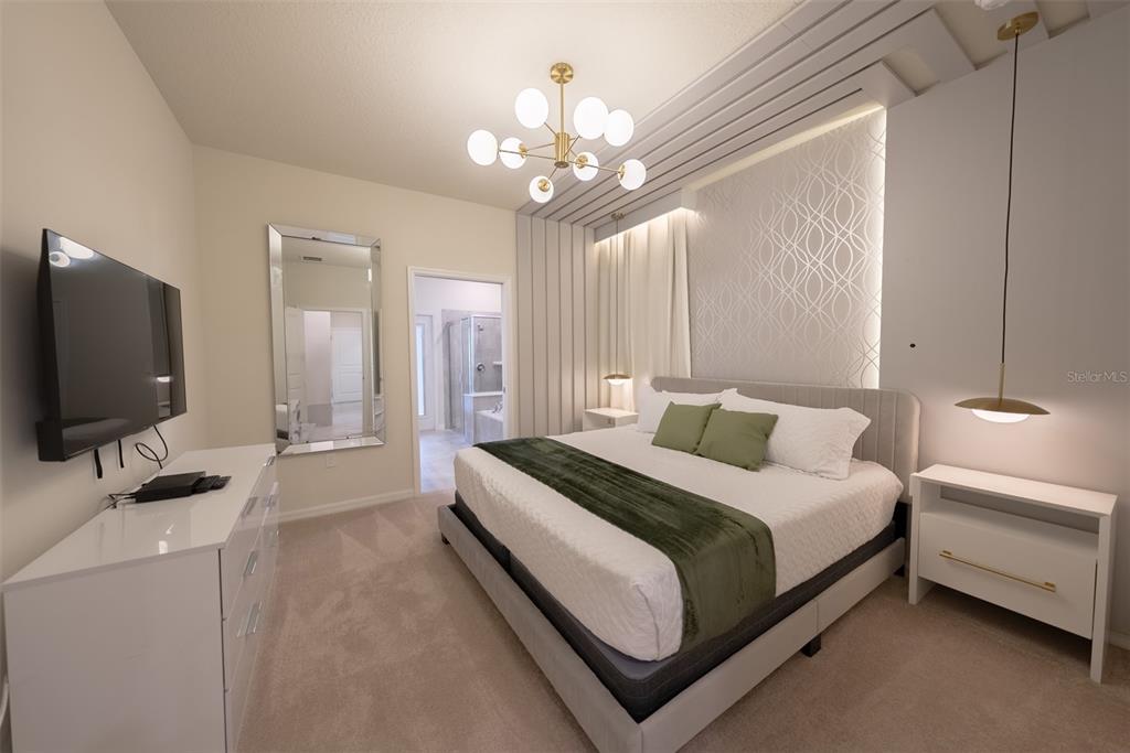 4470 Kaipo Road Davenport, FL 33897 - Photo 11 of 34 a spacious bedroom with a bed and a flat screen tv