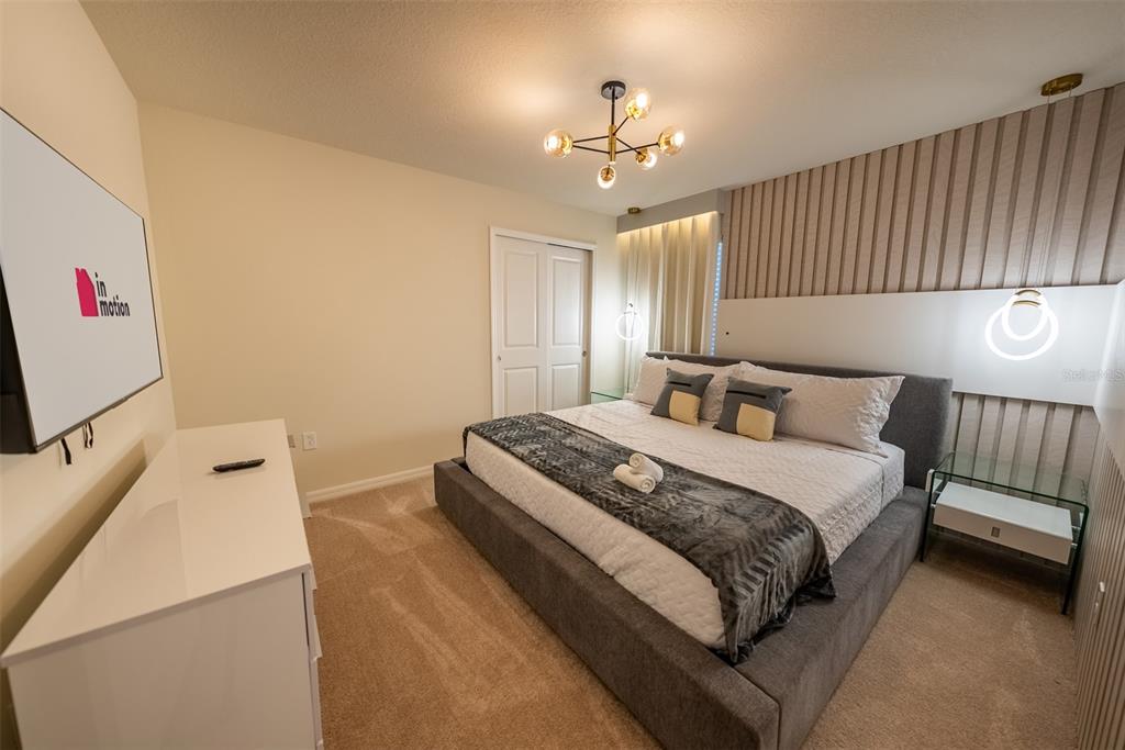4470 Kaipo Road Davenport, FL 33897 - Photo 20 of 34 a bedroom with a bed and a chandelier