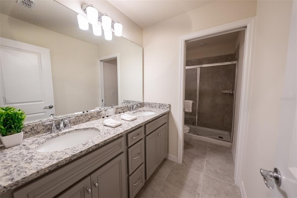 4470 Kaipo Road Davenport, FL 33897 - Photo 22 of 34 a bathroom with a granite countertop sink and a mirror