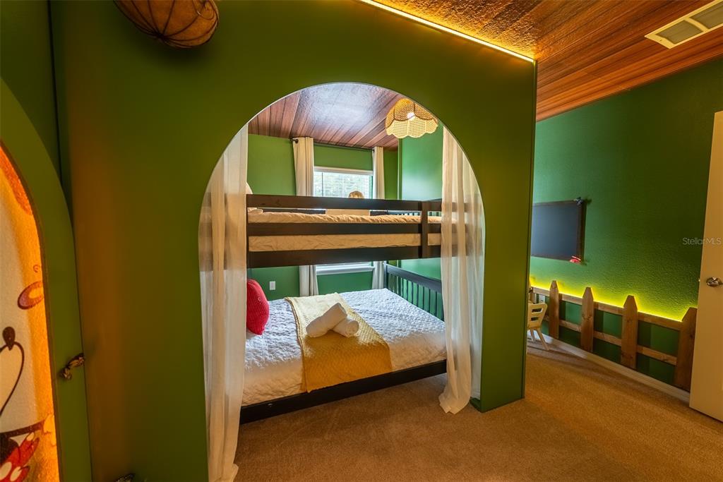 4470 Kaipo Road Davenport, FL 33897 - Photo 28 of 34 a bed room with a bed and a painting on the wall