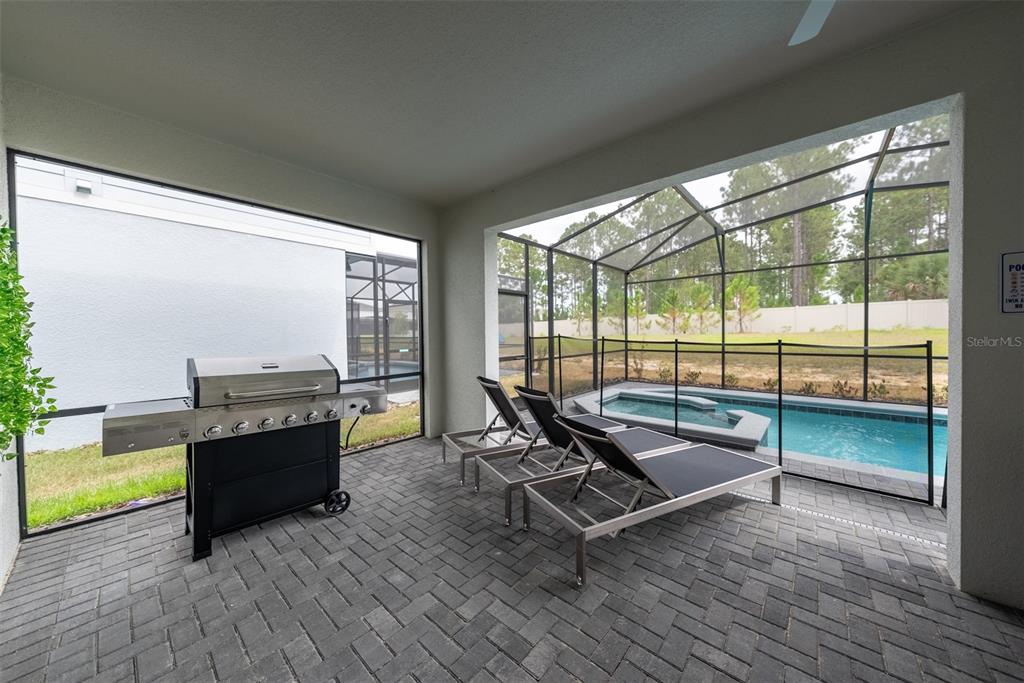 4470 Kaipo Road Davenport, FL 33897 - Photo 32 of 34 a living room with furniture and a floor to ceiling window