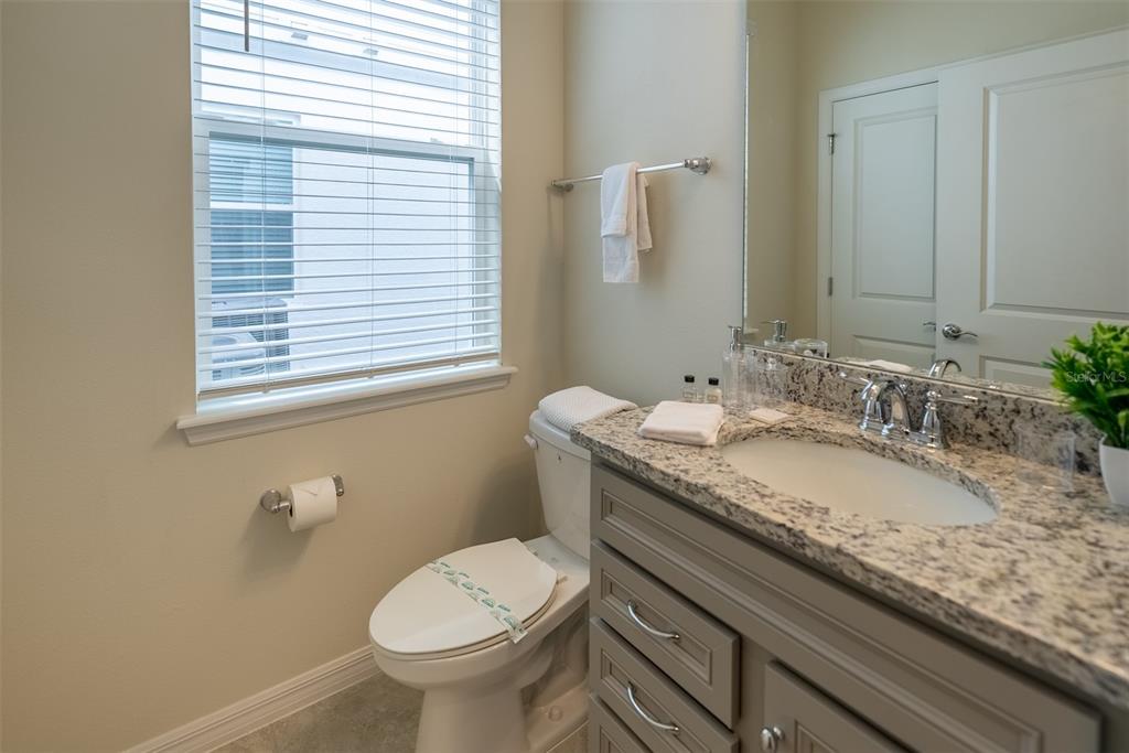 4470 Kaipo Road Davenport, FL 33897 - Photo 9 of 34 a bathroom with a granite countertop toilet a sink and a mirror