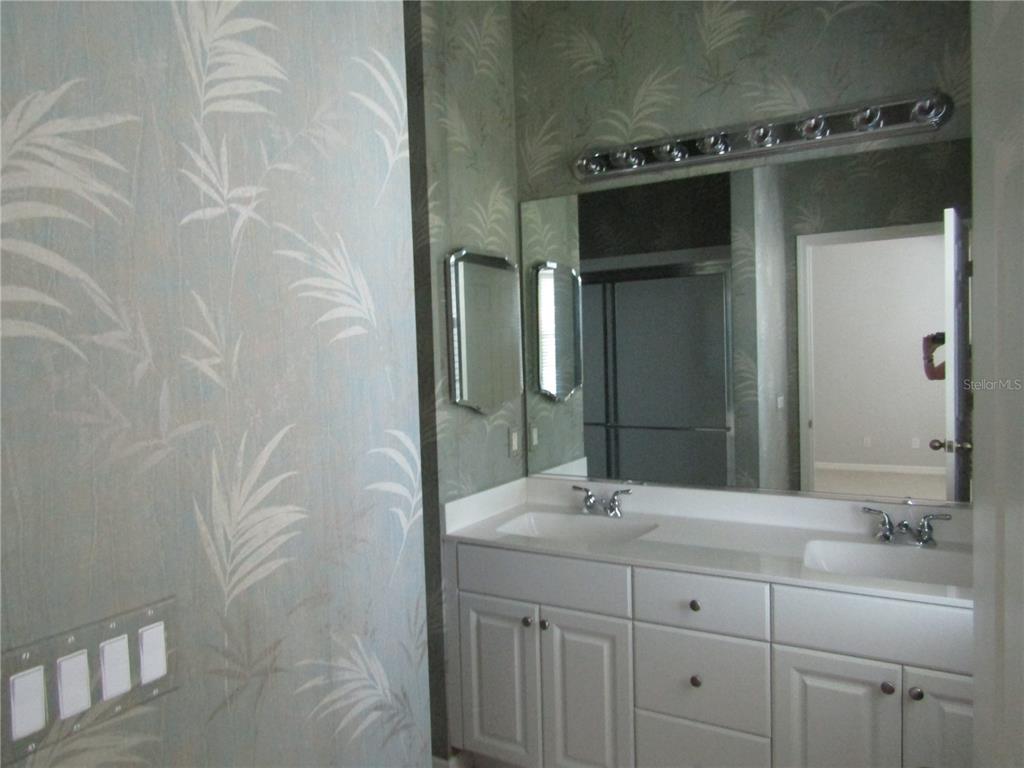 1669 Monarch Drive, Unit 204 Venice, FL 34293 - Photo 11 of 17 a bathroom with a double vanity sink and mirror