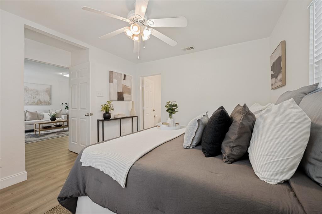 2316 Cunningham Street Irving, TX 75062 - Photo 12 of 22 Bedroom featuring light wood-finish flooring, a white ceiling fan with integrated lighting, and a white paneled door