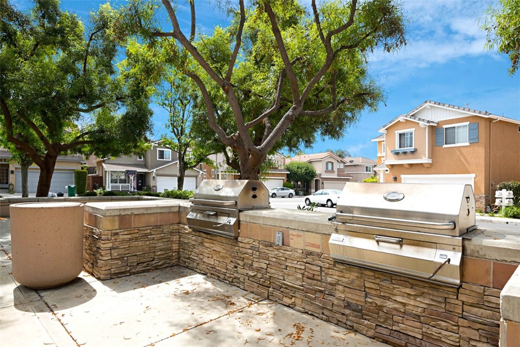 56 Acorn Ridge Rancho Santa Margarita, CA 92688 - Photo 49 of 57 Community Barbecue Area: Built-in stainless-steel grills and stone counters create a convenient outdoor cooking space within the community.