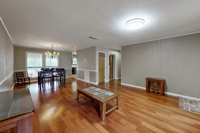a living room with furniture and a wooden floor