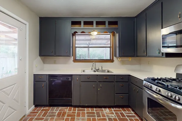 a kitchen with a sink a stove and cabinets