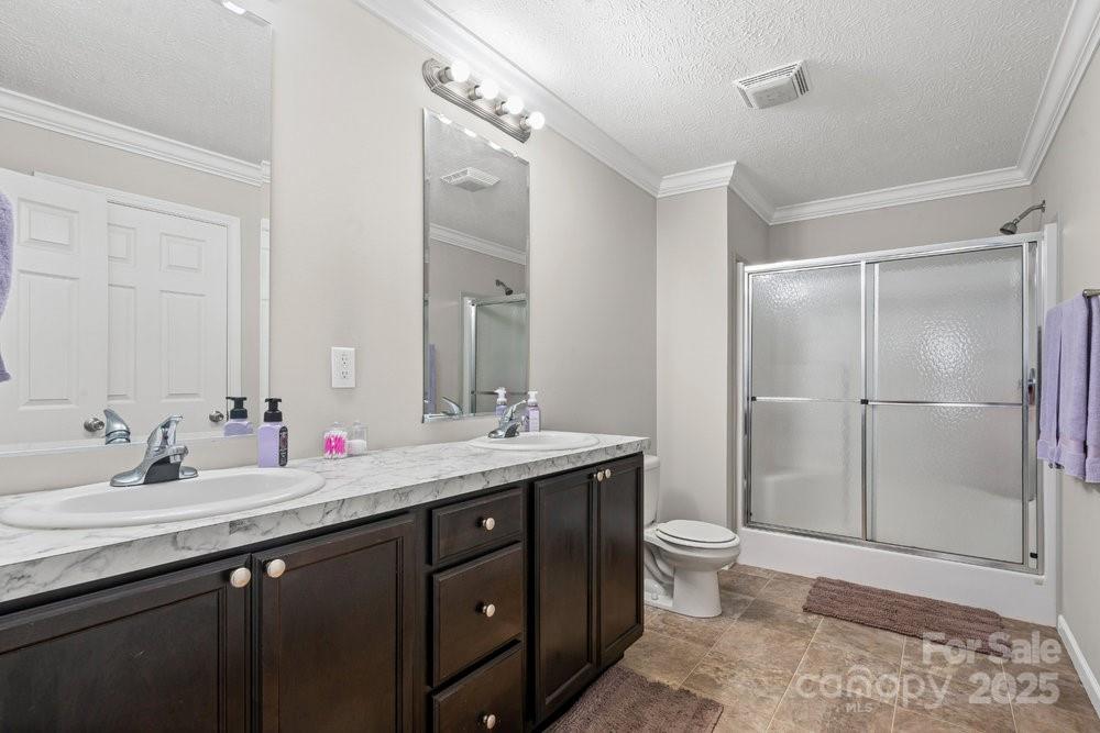 402 Shiloh Road Statesville, NC 28677 - Photo 25 of 34 a bathroom with a double vanity sink toilet and shower