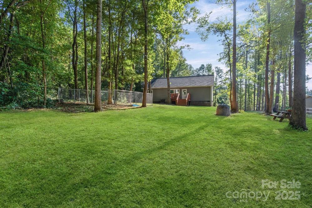 402 Shiloh Road Statesville, NC 28677 - Photo 31 of 34 a view of a backyard with a garden and large trees