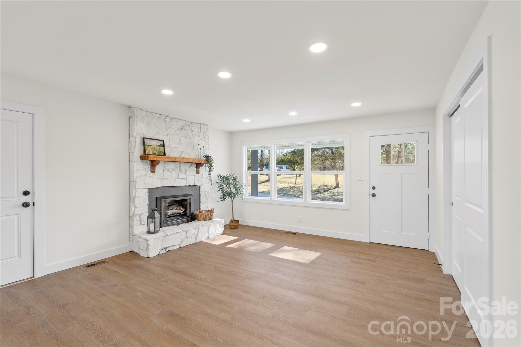 3991 State Rd S-29-330 Lancaster, SC 29720 - Photo 5 of 25 a view of a livingroom with a fireplace a ceiling fan and windows