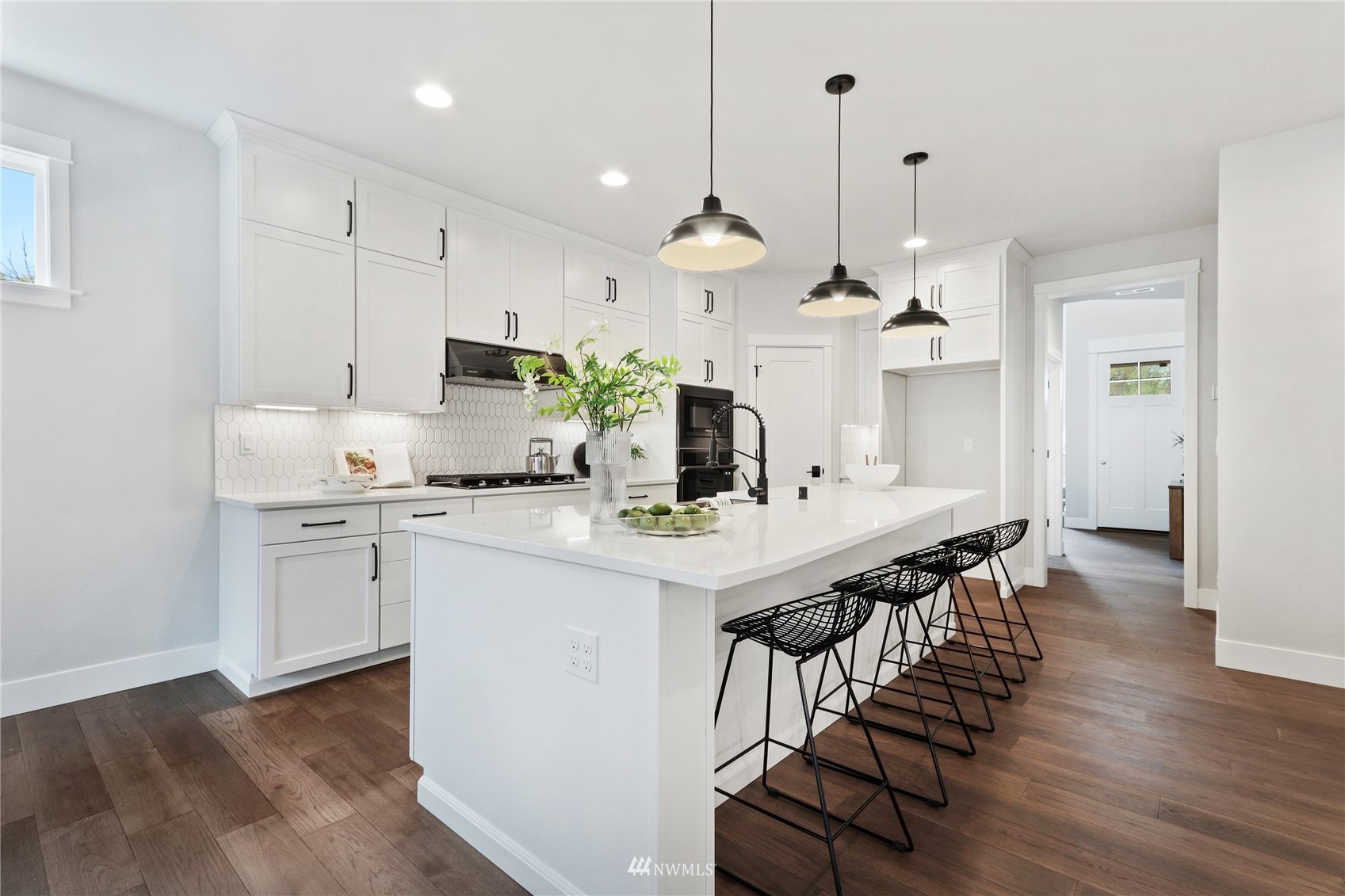 1305 197th Place Southeast Bothell, WA 98012 - Photo 11 of 33 a kitchen with stainless steel appliances kitchen island a refrigerator a stove a sink dishwasher and white cabinets with wooden floor