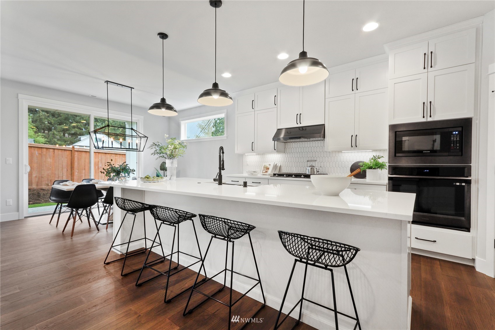 1305 197th Place Southeast Bothell, WA 98012 - Photo 5 of 33 a kitchen with stainless steel appliances granite countertop a stove a sink a microwave a refrigerator with a dining table and chairs with wooden floor