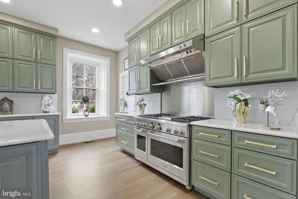 a view of an empty room with wooden floor and windows