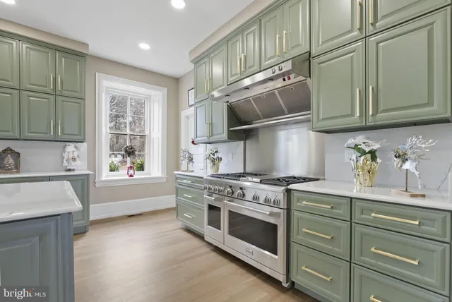 a view of an empty room with wooden floor and windows
