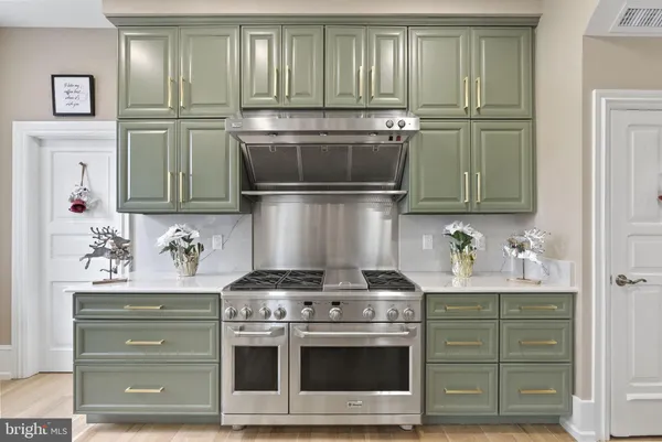 a view of an empty room with wooden floor and a bathroom