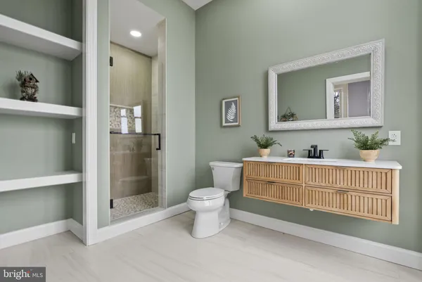 a bathroom with a sink toilet a mirror and shower