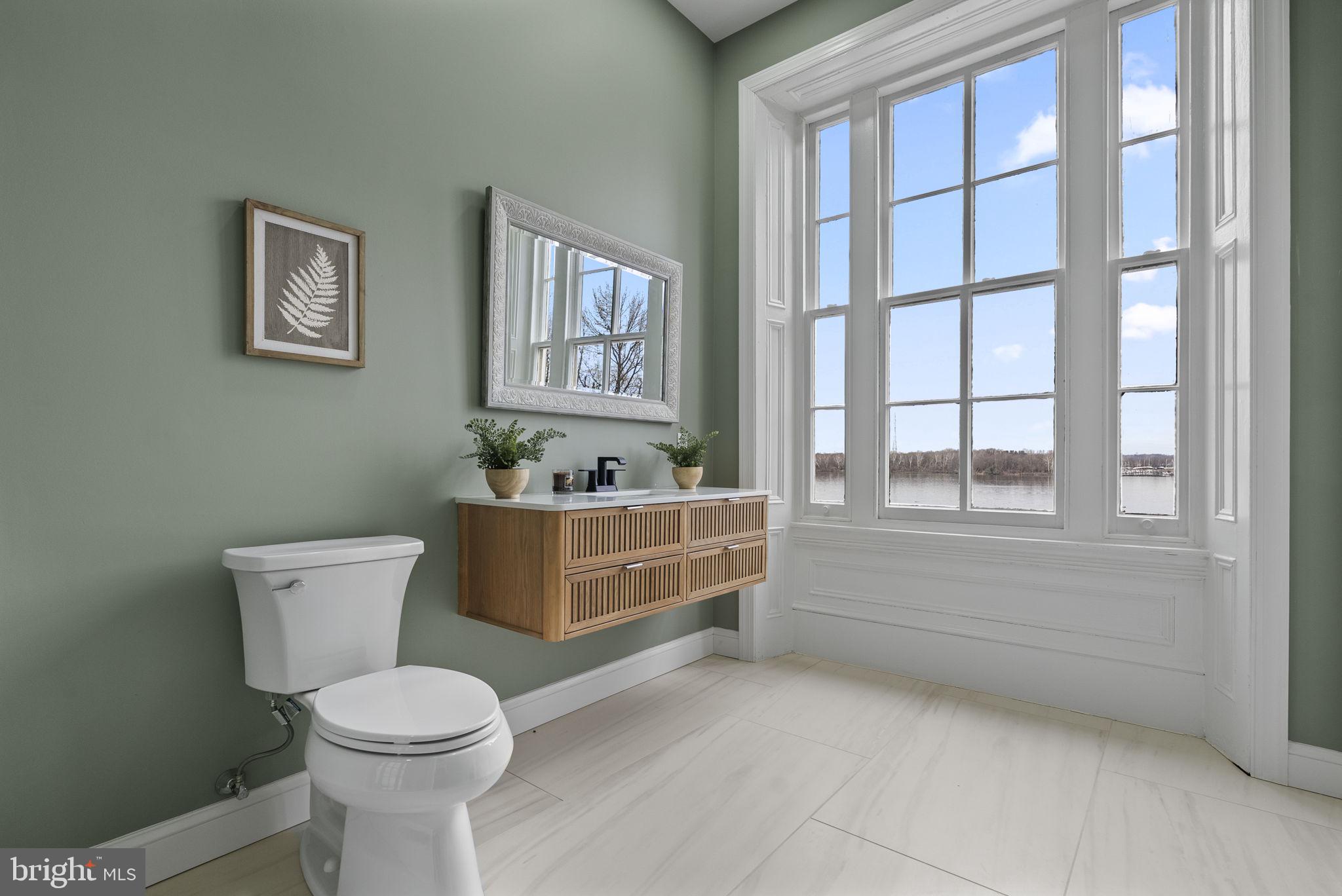 231 Woodlane Road Edgewater Park, NJ 08010 - Photo 49 of 95 a bathroom with a toilet a sink a mirror and a window