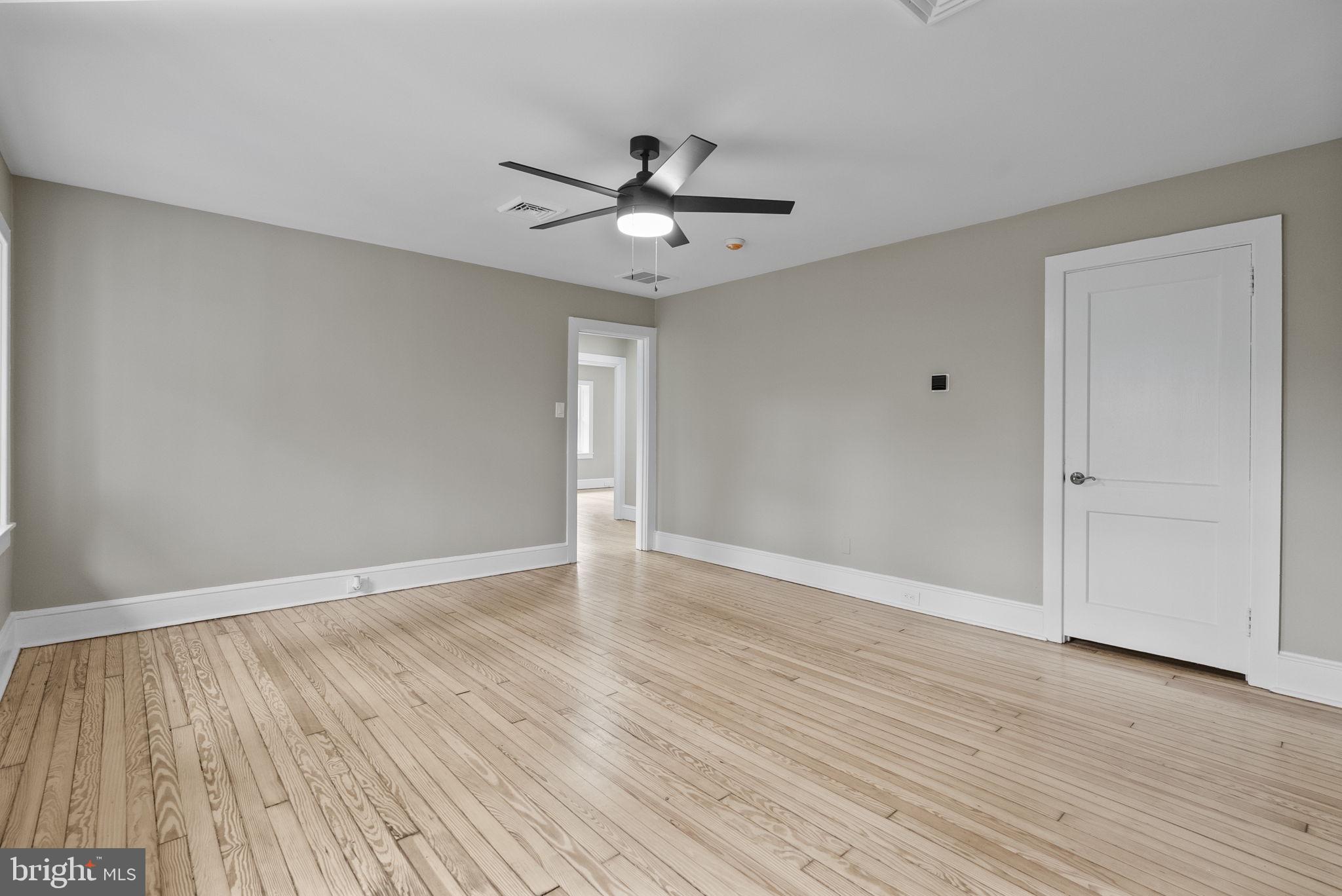 231 Woodlane Road Edgewater Park, NJ 08010 - Photo 67 of 95 an empty room with wooden floor ceiling fan and windows