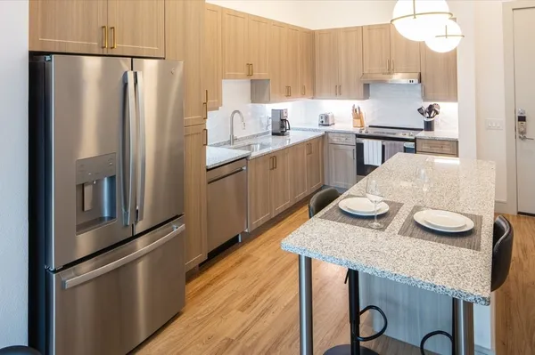 a kitchen with stainless steel appliances granite countertop a sink refrigerator and microwave