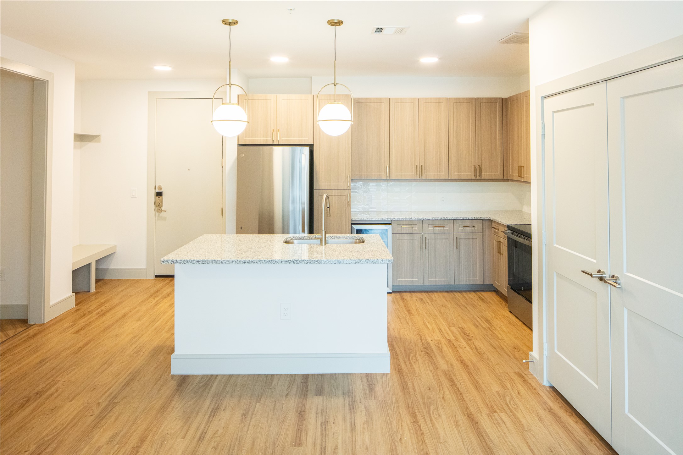 3100 Scofield Ridge Parkway, Unit 1403 Austin, TX 78727 - Photo 9 of 21 a large kitchen with stainless steel appliances a large counter top a sink a refrigerator and a wooden floor