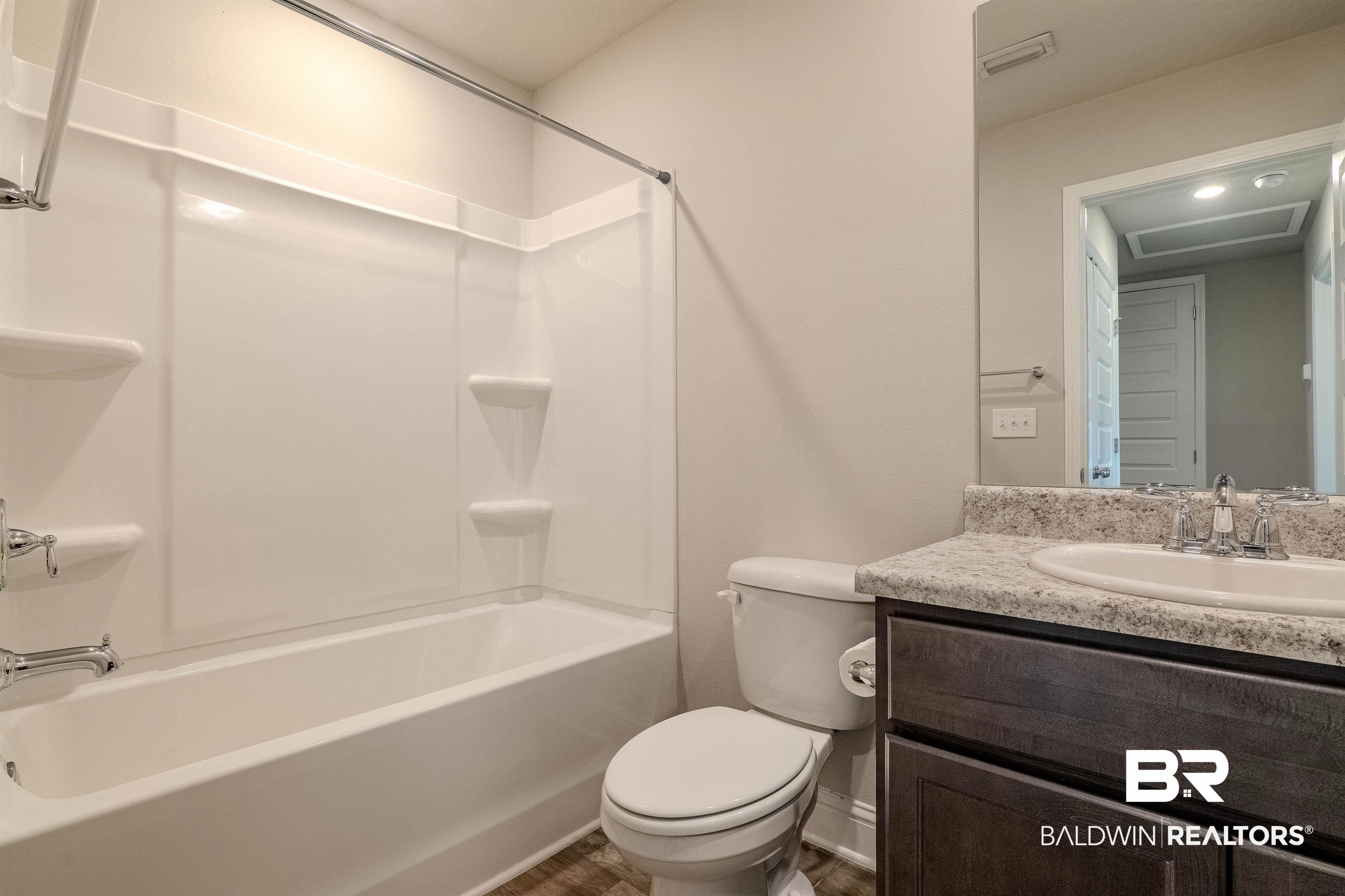 25806 Pollard Road, Unit 32 Daphne, AL 36526 - Photo 17 of 23 Full bathroom with vanity, toilet, and shower / bathing tub combination