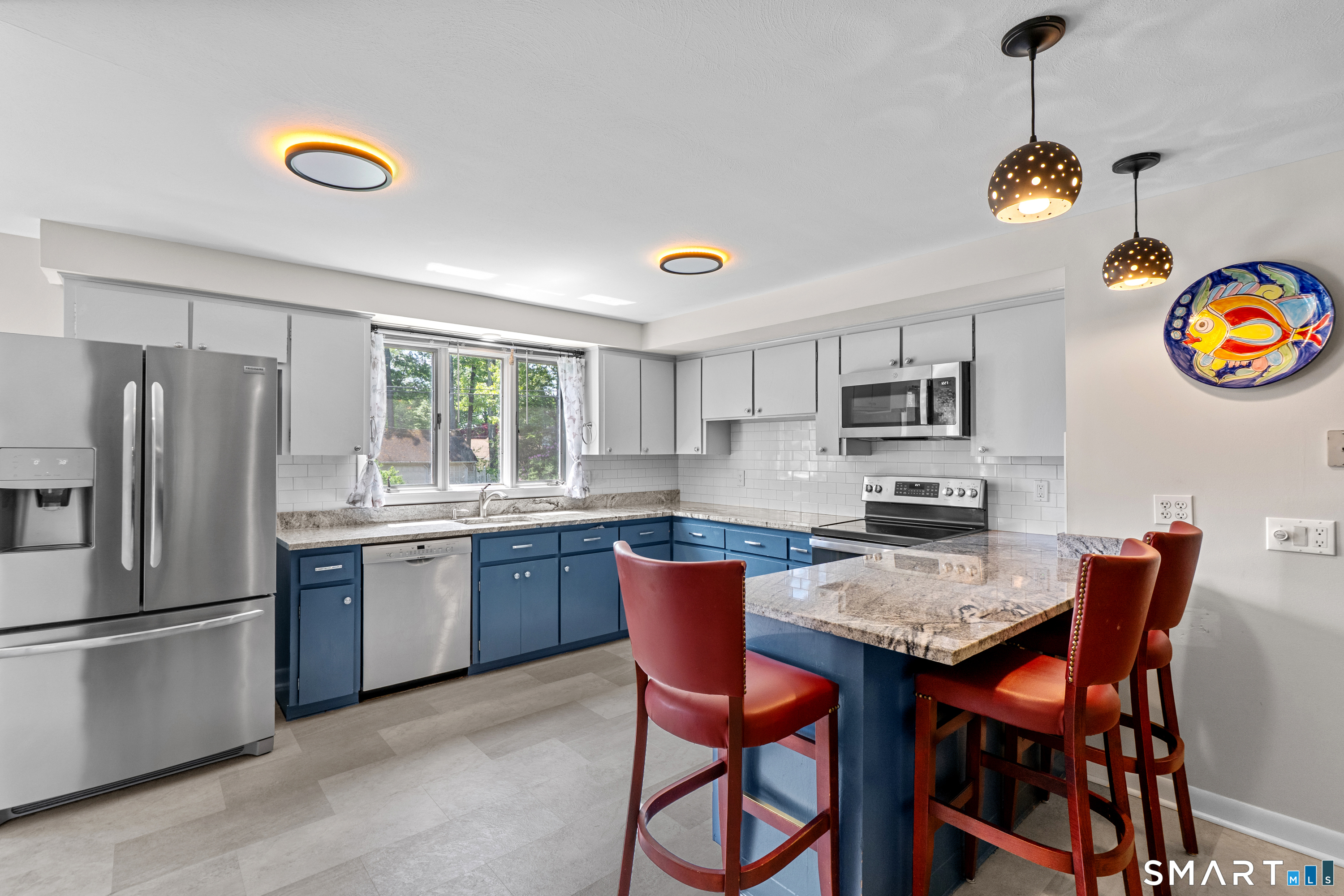107 Round Hill Road Wethersfield, CT 06109 - Photo 13 of 40 a kitchen with stainless steel appliances granite countertop a stove a sink dishwasher a dining table and chairs with wooden floor