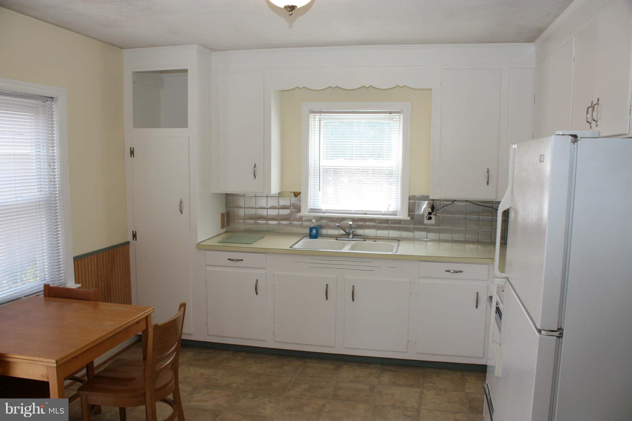 5707 Shookstown Road Frederick, MD 21702 - Photo 10 of 22 a bathroom with granite countertop a sink a window and a refrigerator