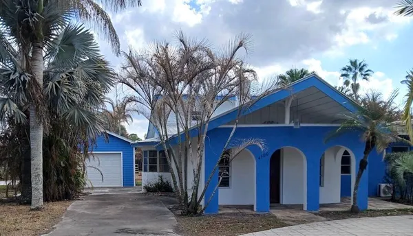 a kitchen with stainless steel appliances kitchen island granite countertop a table chairs in it and a wooden floor
