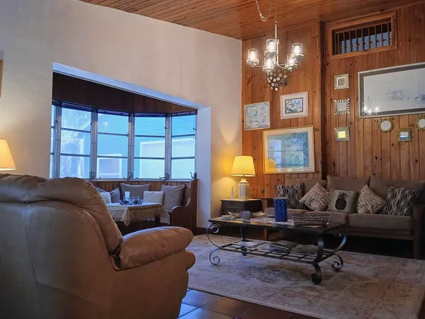a living room with furniture a chandelier and a window