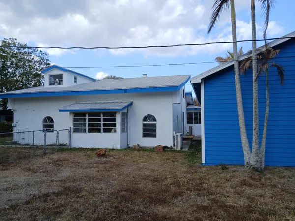 a view of a house with a yard and trees