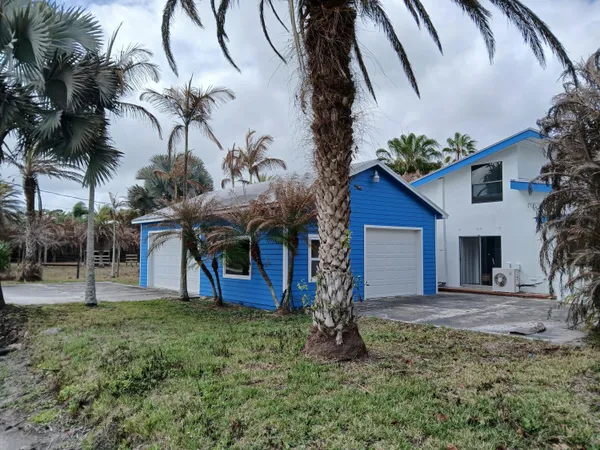 a front view of a house with a garden and yard