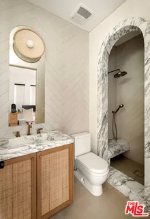 a bathroom with a granite countertop sink a toilet and a mirror