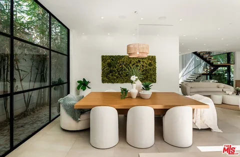 a dining room with furniture a window and potted plants