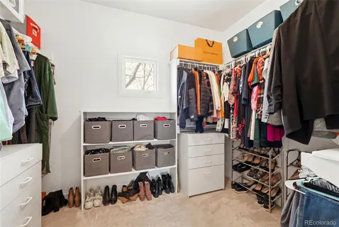 a view of walk in closet with clothes and shoes
