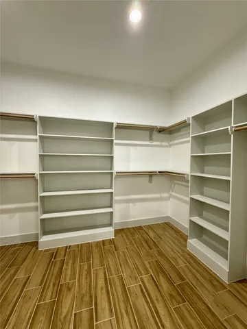 a view of walk in closet with empty racks