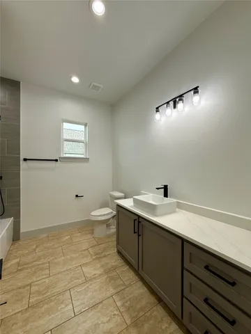 a bathroom with a sink a toilet and a mirror