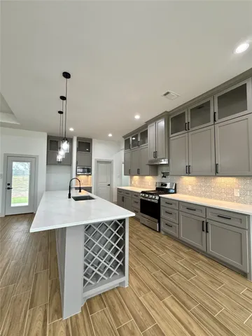 a kitchen with sink cabinets and wooden floor