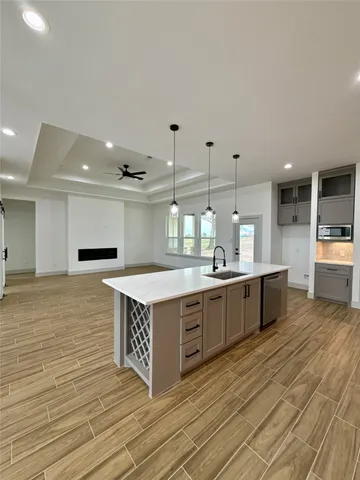 a large kitchen with stainless steel appliances granite countertop a large counter top a stove a sink and a refrigerator