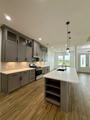 a kitchen with sink cabinets and wooden floor