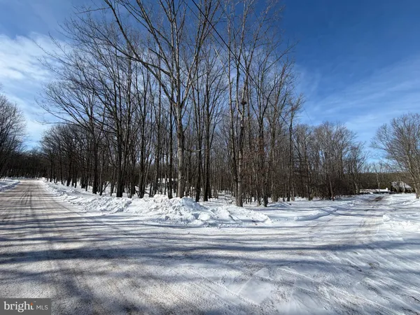 a view of white house with snow on the road