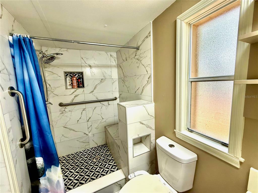 208 Ashley Street Hawthorne, FL 32640 - Photo 19 of 32 a bathroom with a shower and a toilet