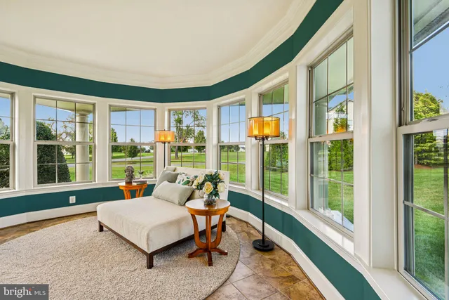 a living room with furniture wooden floor and a large window