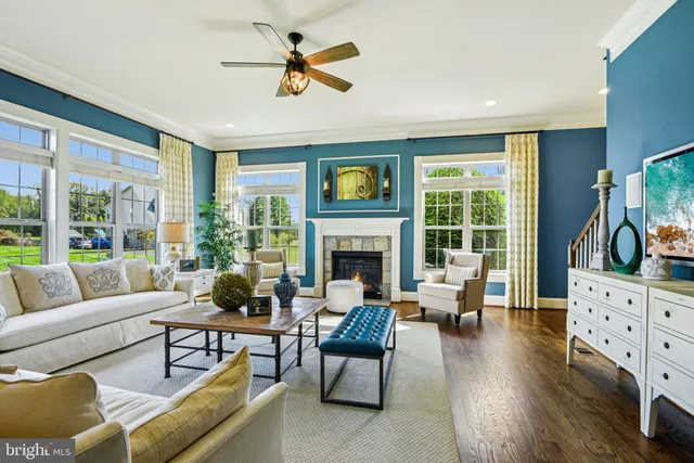 a dining room with furniture a large window and wooden floor