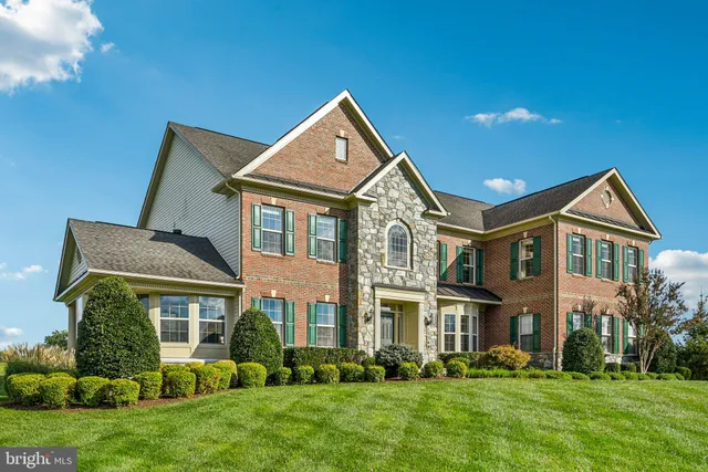 a front view of a house with a yard and trees