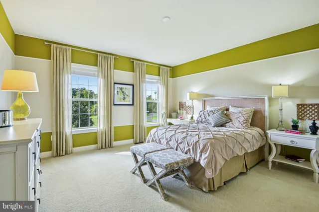 a spacious bedroom with a bed window and couch