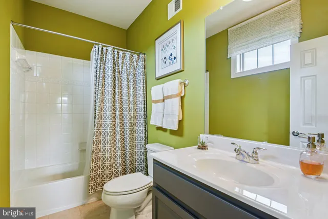 a view of a hallway with wooden floor and livingroom with furniture