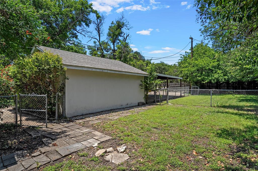 3225 Windsor Avenue Waco, TX 76708 - Photo 23 of 25 Expansive backyard featuring a chain-link fence, mature trees, and a detached building with a shingle roof