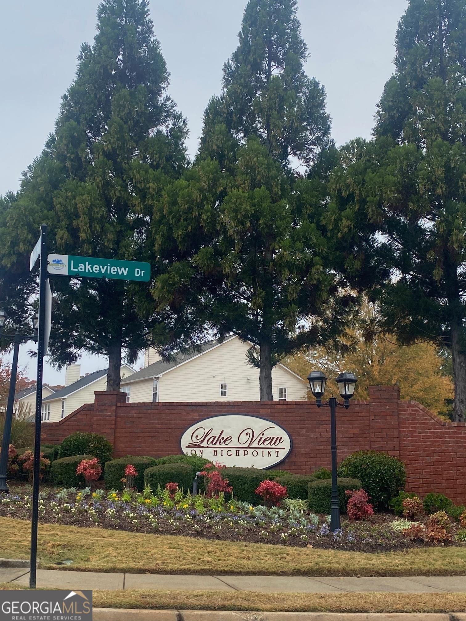 a view of a sign in a yard with large trees