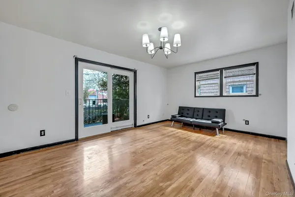 a view of a room with wooden floor chandelier and windows