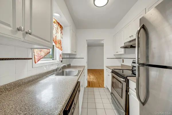 a kitchen with stainless steel appliances a refrigerator sink and stove